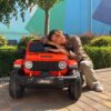 Дитячий повнопривідний електромобіль Bambi Jeep Rubicon (MP3) з багажником, ручкою для транспортування та рухливим капотом, помаранчевий
