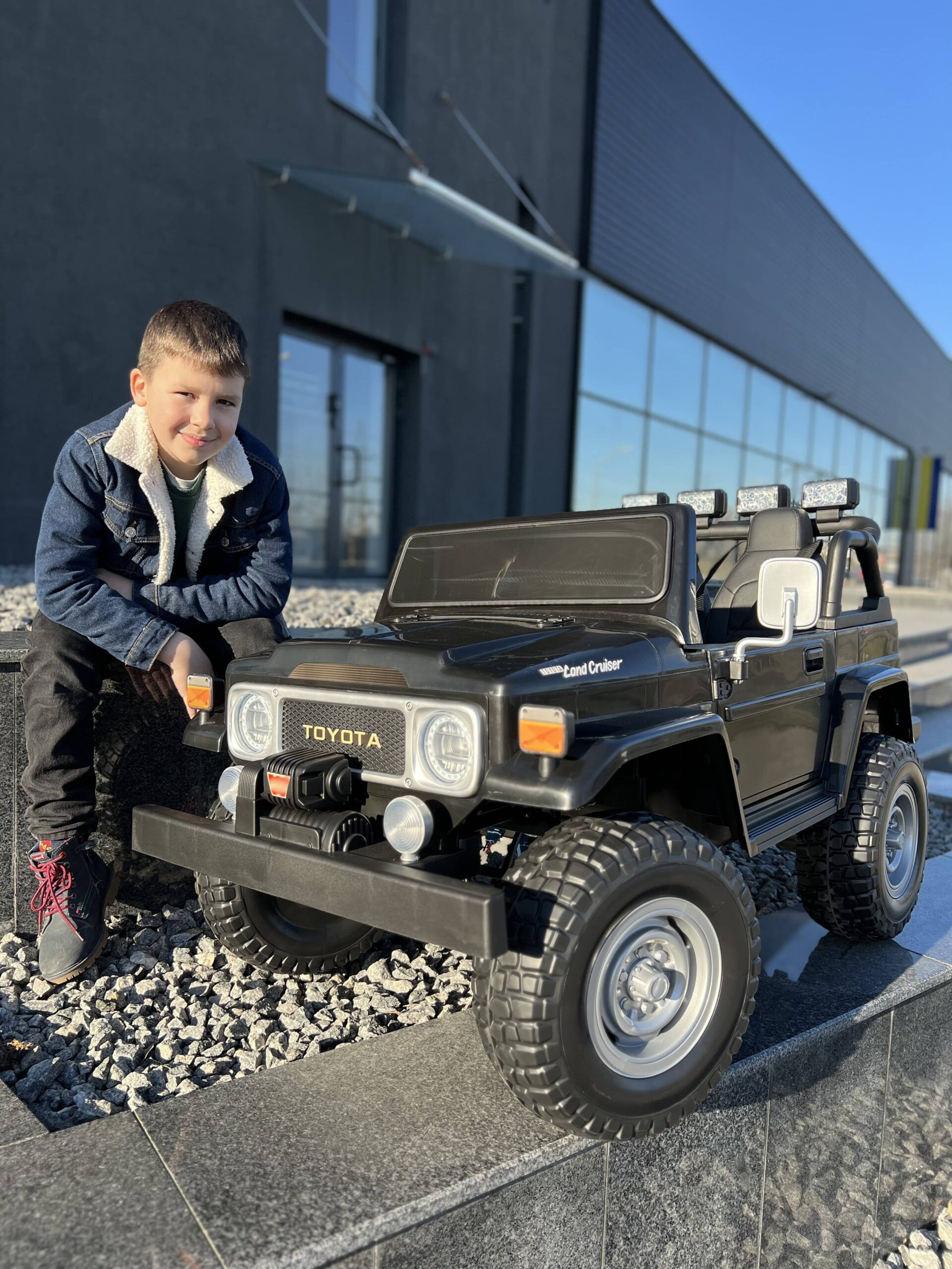 Детский двухместный полноприводный электромобиль Bambi Toyota Land Cruiser (MP3) с ручкой для транспортировки и багажником, черный