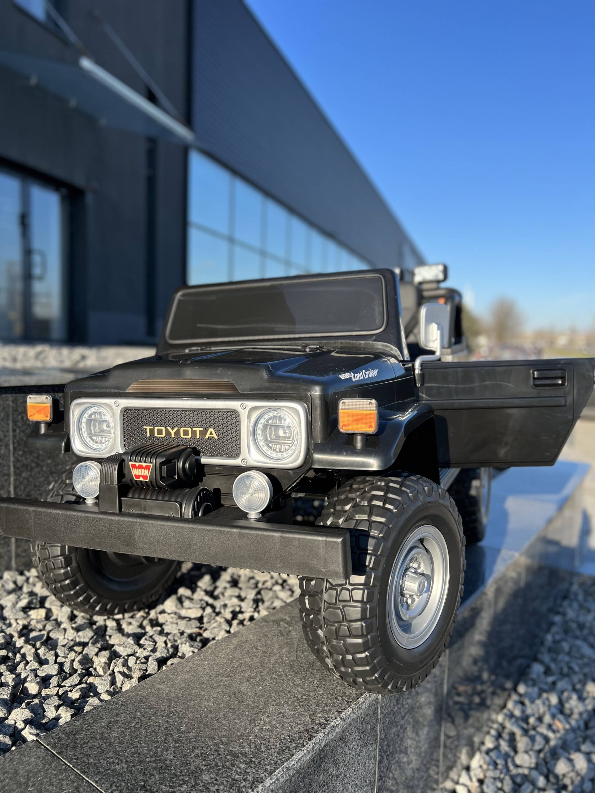 Детский двухместный полноприводный электромобиль Bambi Toyota Land Cruiser (MP3) с ручкой для транспортировки и багажником, черный