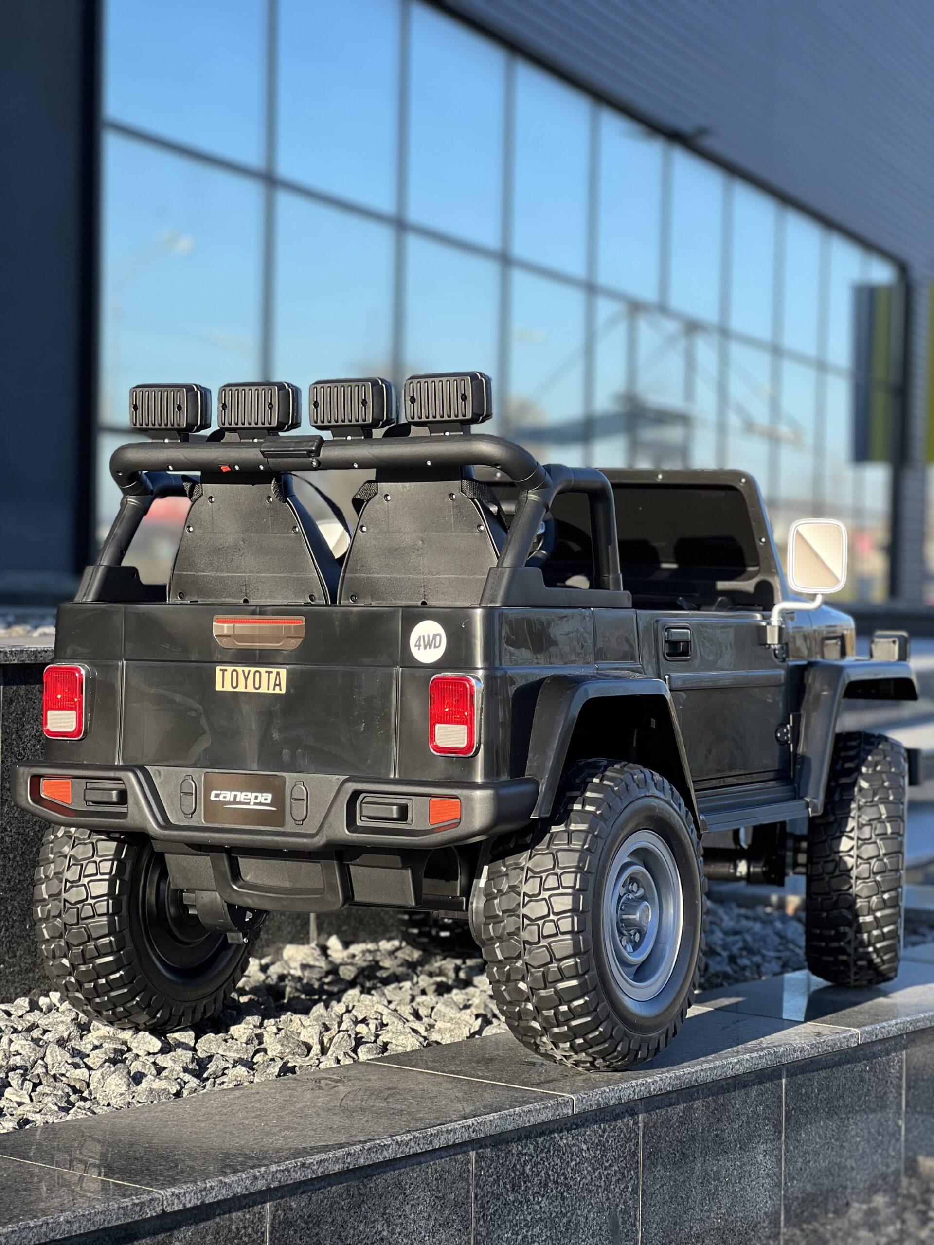 Детский двухместный полноприводный электромобиль Bambi Toyota Land Cruiser (MP3) с ручкой для транспортировки и багажником, черный